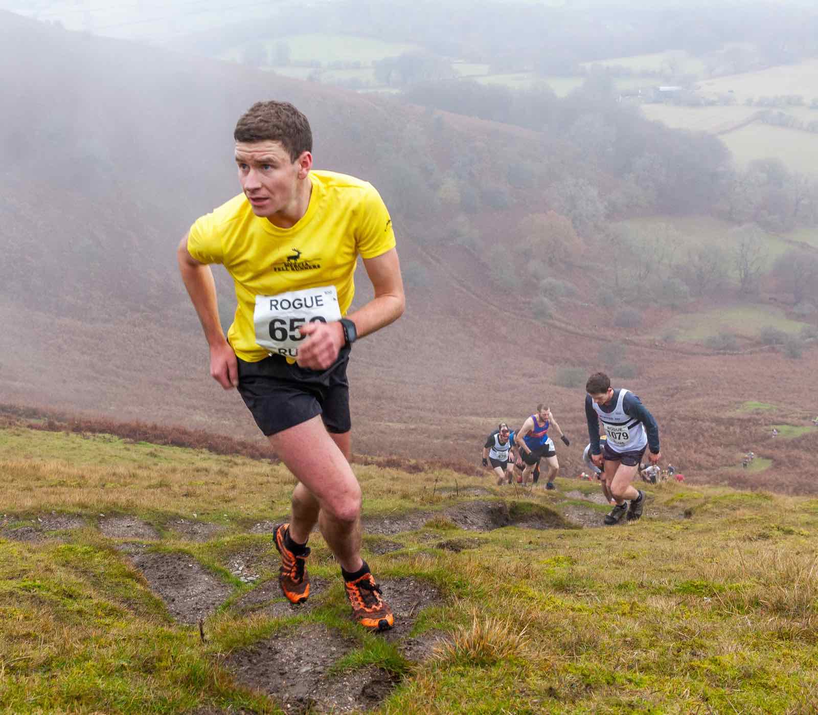 Fell runners climbing the steep open slope of the Blorenge